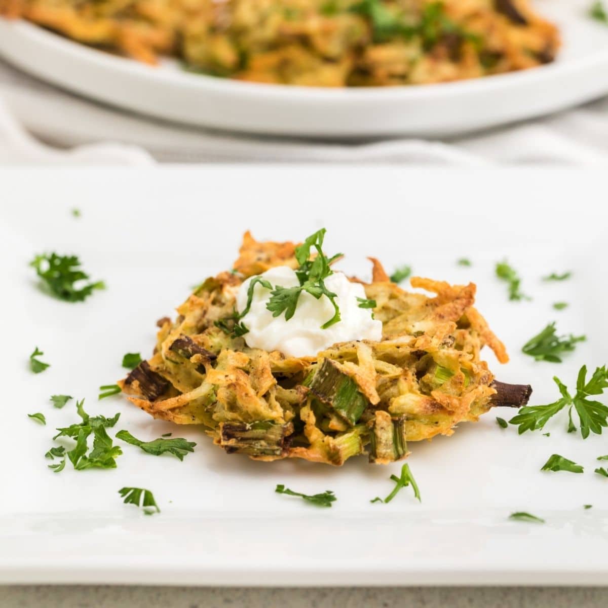 Delicious crispy air fryer potato casserole topped with sour cream and herbs.