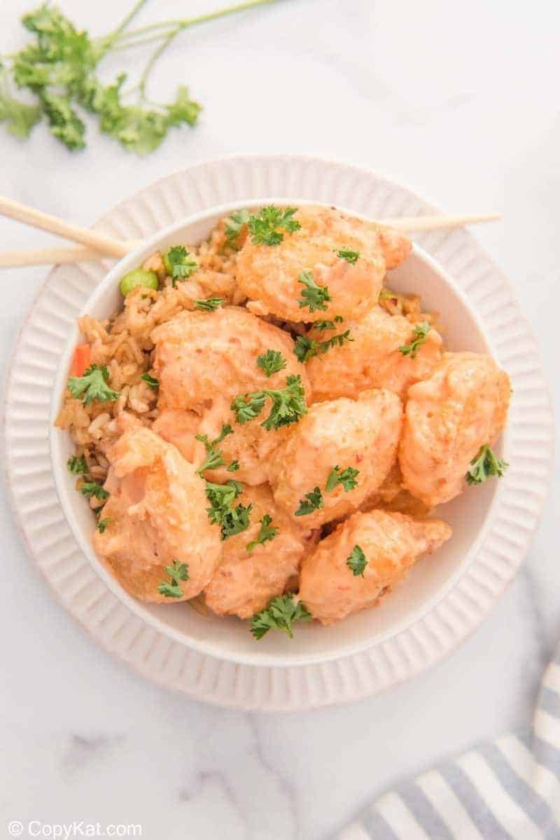 Crispy air fryer shrimp bites garnished with fresh parsley on a white plate.